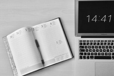 Flat Lay Photography of Unfold Book Beside Macbook