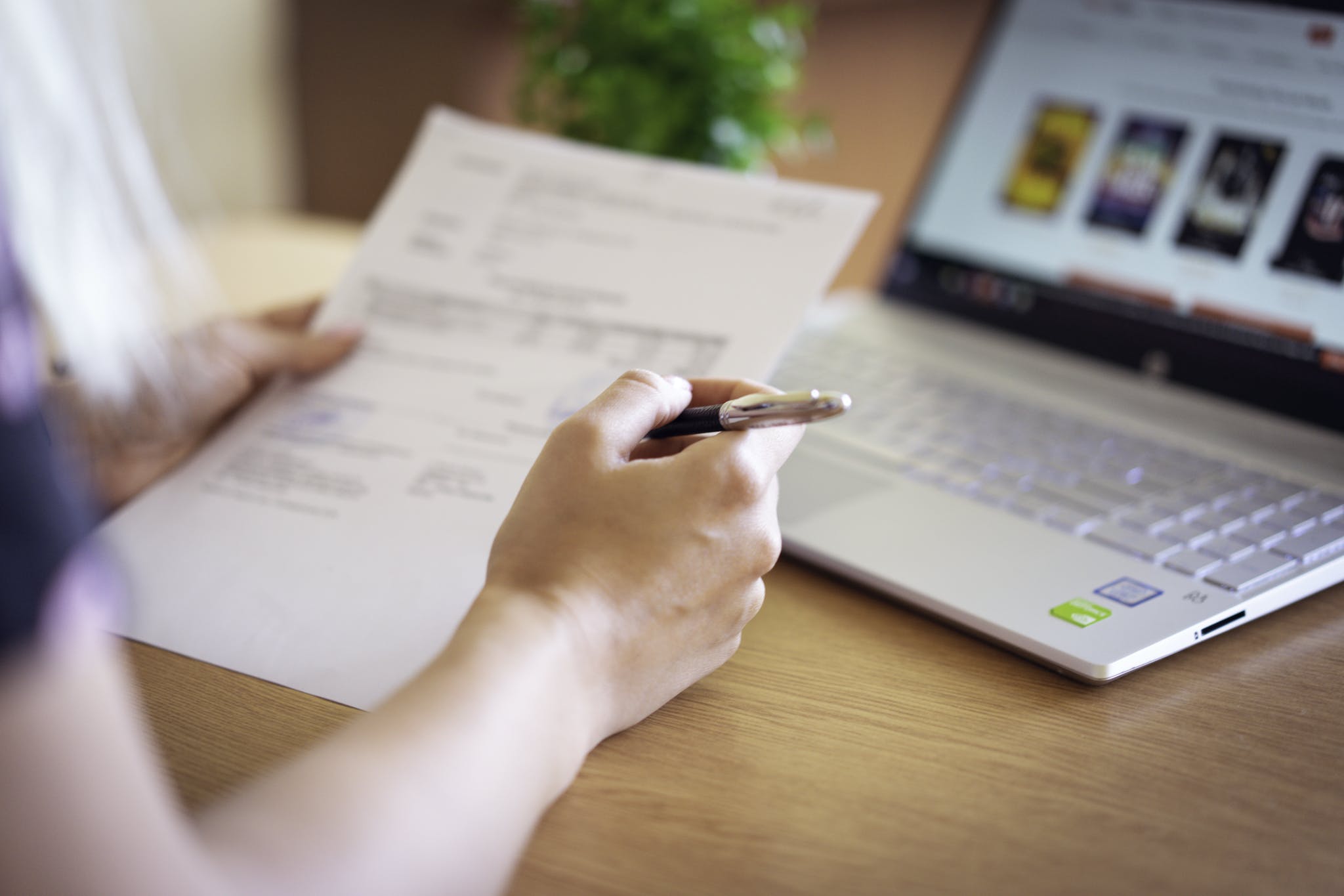 Person Holding Pen And Paper